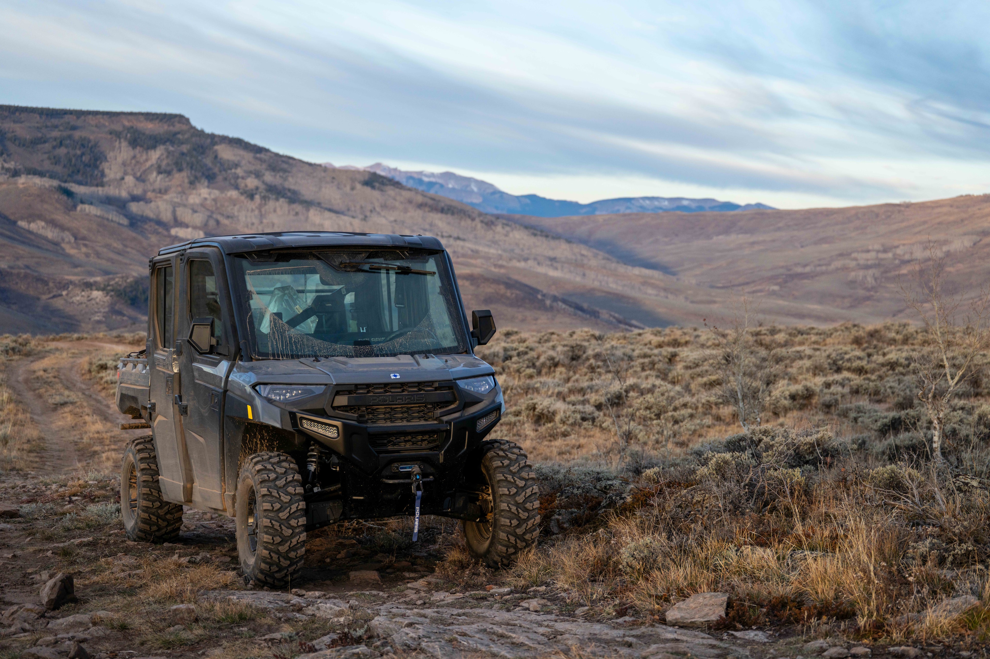A vehicle navigating rugged terrain on the way into the field